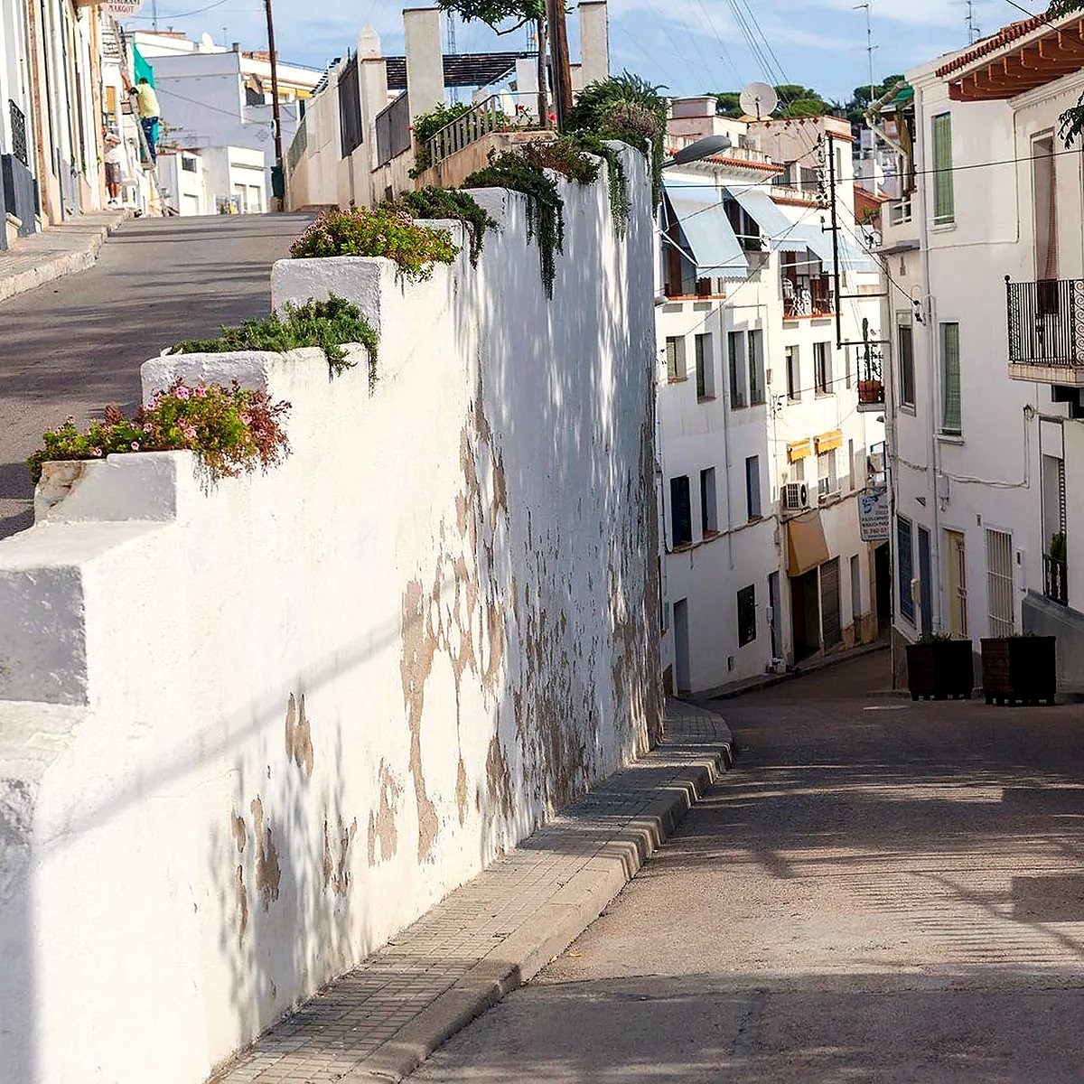 Calle en pendiente con casas blancas en el Maresme